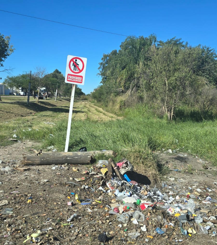 Un cartel, una prohibición y una montaña de basura